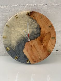 a clock made out of wood and marble with roman numerals on the face