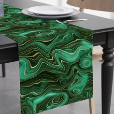 a table with a green and gold marbled design on it, next to a white plate