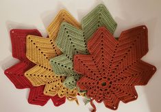 four crocheted doily are arranged on top of each other in different colors