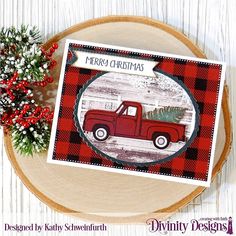 a red truck with a christmas tree on the back is sitting next to a pine branch