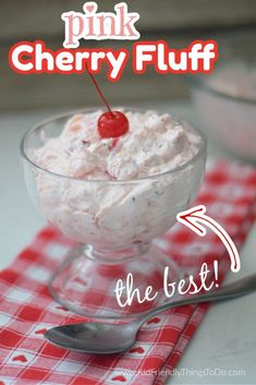 pink cherry fluff in a glass bowl with a spoon and red checkered napkin