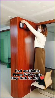 a woman in white shirt and brown skirt standing next to a wooden cabinet