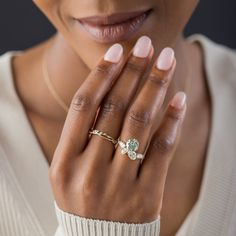 a close up of a woman's hand with a ring on her left hand