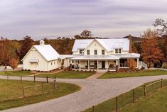 a large white house sitting on top of a lush green field