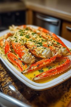 there is a plate of cooked lobsters on the kitchen counter with lemon sauce and parsley