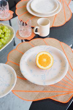 the table is set with orange and grapes