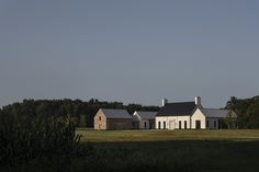 a large white house sitting on top of a lush green field