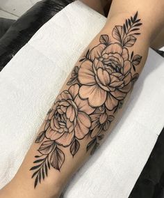 a black and white flower tattoo on the arm