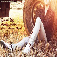 a man sitting in the grass next to a tractor tire with his feet on the ground