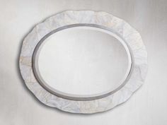 a white plate sitting on top of a table next to a silver metal wall mounted mirror