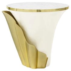 a white and gold vase sitting on top of a table