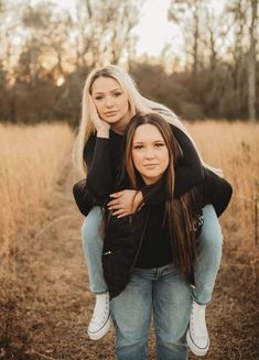 two women are hugging in the middle of a field