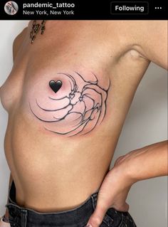 a woman's breast with a heart tattoo on it