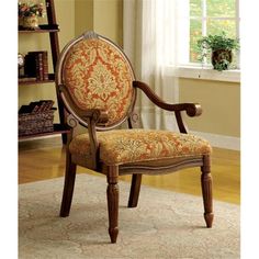 the arm chair is upholstered with an orange and gold floral pattern on it