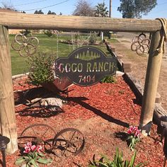 a sign that says coco ranch in front of some flowers and plants on the ground