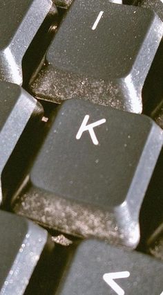 a close up view of a keyboard with white letters on it's black keys