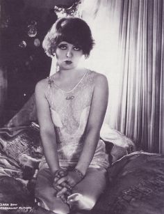 black and white photograph of a woman sitting on a bed