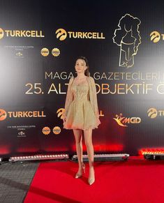 a woman standing on top of a red carpet