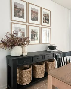 a black table with baskets and pictures on the wall