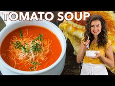 a woman holding a spoon in front of a bowl of tomato soup and toasted bread