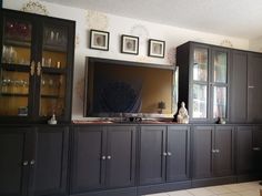 a living room with black cabinets and a flat screen tv on top of the entertainment center