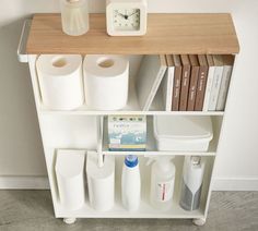 a shelf with toiletries, books and a clock sitting on it's side