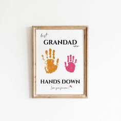 a wooden frame hanging on the wall displaying two hand prints that say grandad and hands down