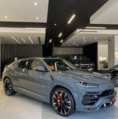 a grey lamb suv parked in a showroom