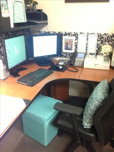 an office desk with two computer monitors and a keyboard on it, along with a blue footstool