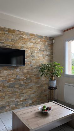 a living room with a television mounted on the wall and a table in front of it