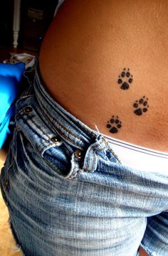 a woman's lower back with paw prints on her left side and the bottom part of her stomach