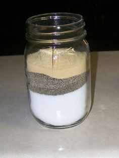 a glass jar filled with sand and white liquid