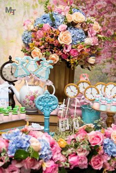 a table topped with lots of different types of flowers and clocks next to each other