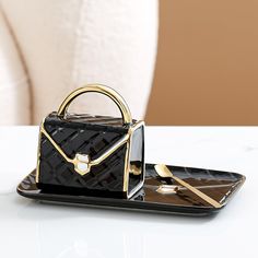 a black and gold purse sitting on top of a tray