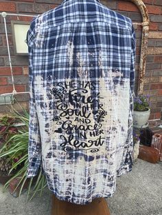 a blue and white shirt with writing on it sitting on top of a wooden stand