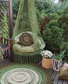 a hammock chair sitting on top of a wooden deck next to a potted plant