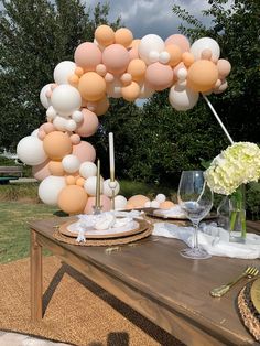 the table is set with balloons and place settings for an outdoor dinner or brunch