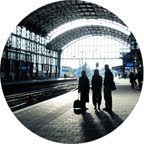 three people are standing at the train station