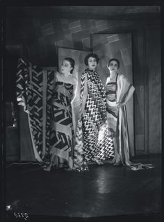 three women standing next to each other in dresses