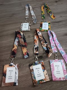 several lanyards with name tags attached to them on a wooden surface, including one for the photographer and two for the photographer