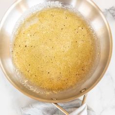 a pan filled with food sitting on top of a counter next to a white towel