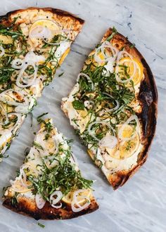 four slices of pizza topped with cheese and veggies on a marble counter top