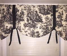 a window curtain with black and white toilers on it