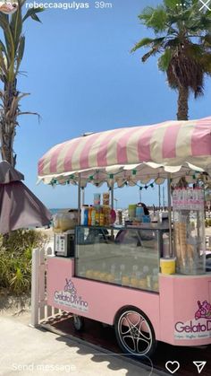 an ice cream cart on the beach with palm trees