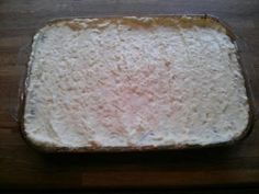 an uncooked casserole dish sitting on top of a wooden table