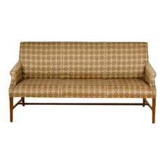 a brown and white couch sitting on top of a wooden frame with an upholstered back