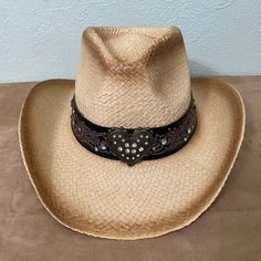 Straw Cowboy Hat, Brown Antiqued with a Beautiful Heart Shaped Medallion Embellished with Rhinestones and Scroll Headband with Rhinestones. This Shapeable 100% straw cowboy hat is perfect for any occasion. The hat band adds unique western flair. This hat is great for him or her!  The one size elastic hat band on the inside of the hat makes this hat fit most everyone.  The wire brim allows the owner to style and shape the hat to his or her liking. Material: Straw Sizing: one size fits most. It wi Embellished Adjustable Hat With Curved Brim, Adjustable Rhinestone Hat Bands For Western-themed Events, Adjustable Embellished Hat For Festivals, Adjustable Rhinestone Hat Bands For Festivals, Adjustable Embellished Festival Hats, Western Adjustable Hats With Rhinestones, Adjustable Bling Hat For Country Events, Cowboy Hat Brown, Straw Cowboy Hat