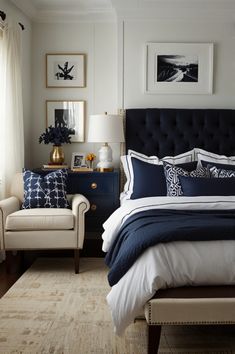 a bedroom with blue and white bedding, two chairs and pictures on the wall