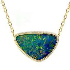 "This beautiful sky blue Opal doublet is framed by 14 karats yellow gold, set with U set Diamonds. This will make the perfect gift for October's baby. This is from our \"Opalescence collection\". It comes with an 18\" chain. Each stone is unique and natural, one of a kind, handpicked. We design it based on the shape of the stone, to give it its unique personality. [MATERIALS] Stones: Opal (1) Carat: 31.03 Clarity: No inclusions Cut: Abstract Cabochon Doublet Transparency: Opaque Play of Color: B Flower Diamond Ring, October Baby, Unique Opal, Blue Opal Necklace, Red Opal, Art Nouveau Pendant, Jewelry Opal, Necklace Opal, Opal Ring Gold