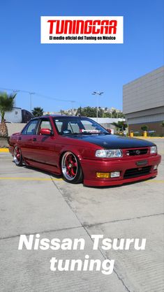 a red car parked in front of a building with the words nissan tsuru tuning on it